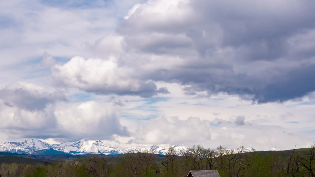 多云的天空，雪山的冬天背景。树林上方的蓝天和灰云。在金色的天气里，蓬松的云在大气中飞舞。美丽的自然空气雨云景观视频下载