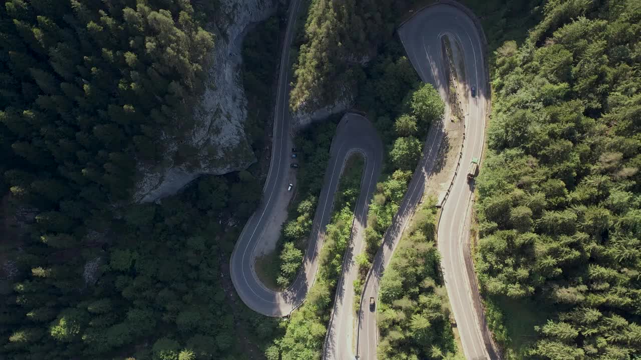 弯弯曲曲的柏油路在山上。鸟瞰图的道路穿过山和绿色的森林。视频素材