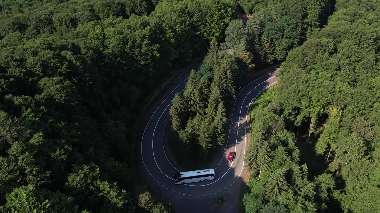 弯弯曲曲的柏油路在山上。鸟瞰图的道路穿过山和绿色的森林。视频素材