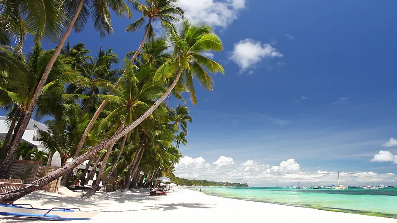 原始的海滩上有棕榈树，白色的沙滩和绿松石般的热带海洋。旅游目的地视频下载