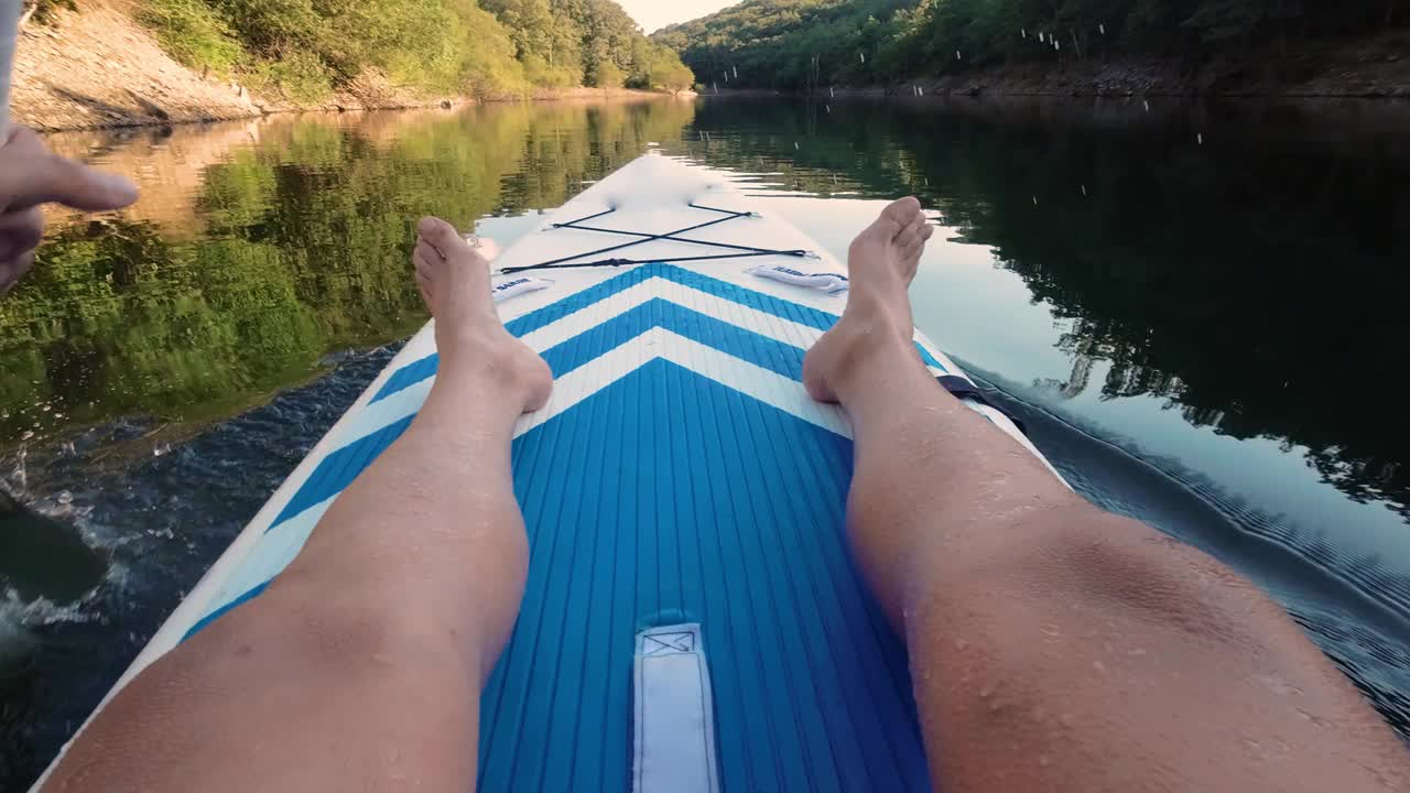 在湖中划皮艇。男子皮划艇在美丽的风景的POV。夏季期间的水上运动概念。风景优美，平静，轻松，温馨。视频素材