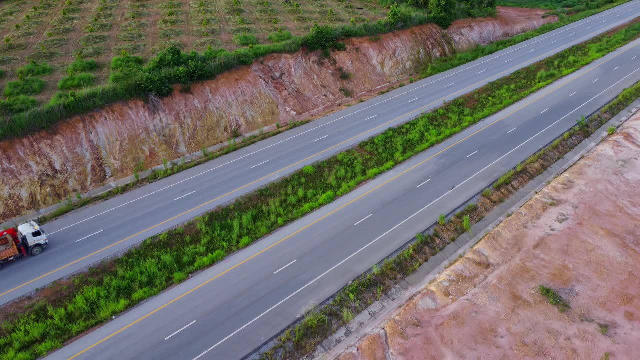 鸟瞰图乡村柏油路与汽车和绿色的森林。行驶在绿色森林之间的道路上。视频素材