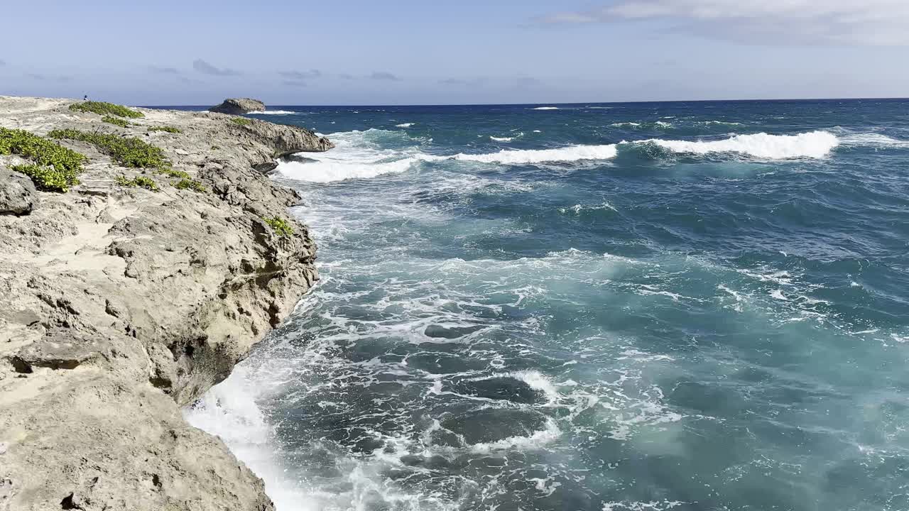 海浪撞击着瓦胡岛崎岖的海岸悬崖，创造了一个充满活力和活力的海景，清澈，深蓝色的海水。视频素材