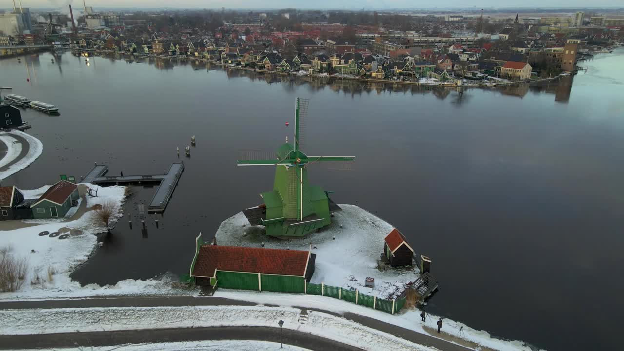 荷兰，有风车和河流的白雪村庄鸟瞰图。视频下载