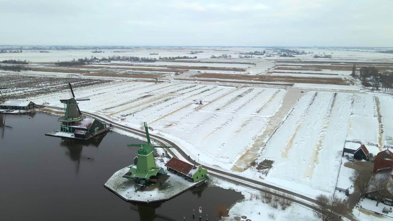 荷兰，白雪覆盖的村庄，风车和河流的鸟瞰图。视频素材