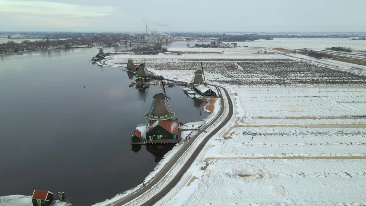 鸟瞰图:荷兰，有风车和河流的白雪皑皑的荷兰村庄。视频素材