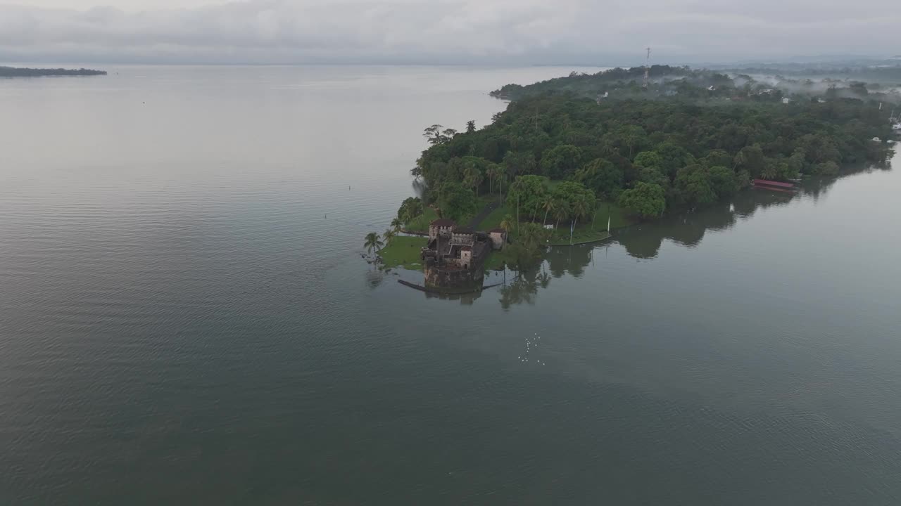 鸟瞰图中世纪城堡与宁静的湖泊，危地马拉岛。视频下载