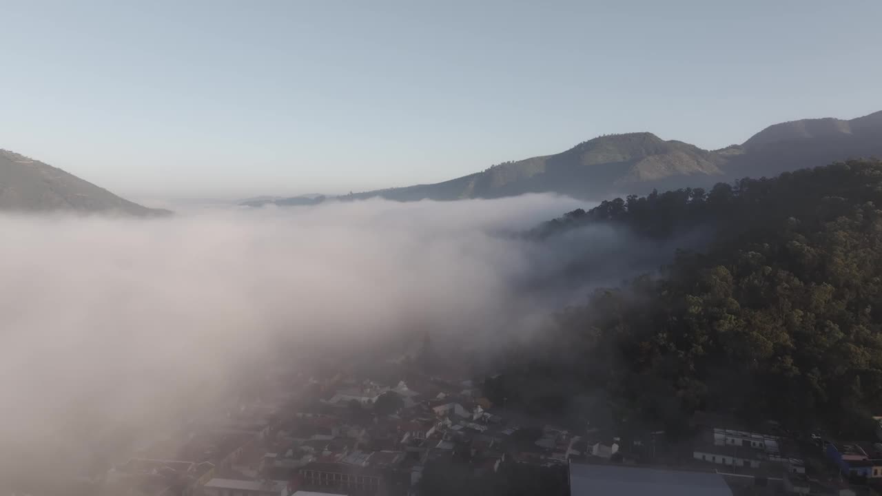 鸟瞰图，雾蒙蒙的城市，迷雾的山脉，风景秀丽的山谷，危地马拉。视频素材