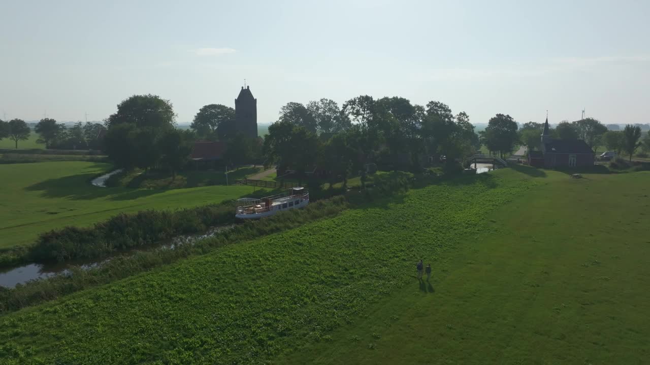 鸟瞰宁静的荷兰村庄，有绿色植物和河流，荷兰。视频素材