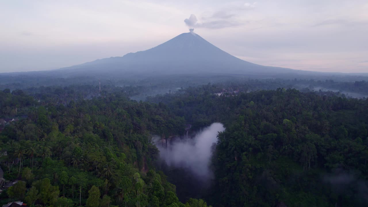 鸟瞰印尼茂密森林中的瀑布和火山。视频素材