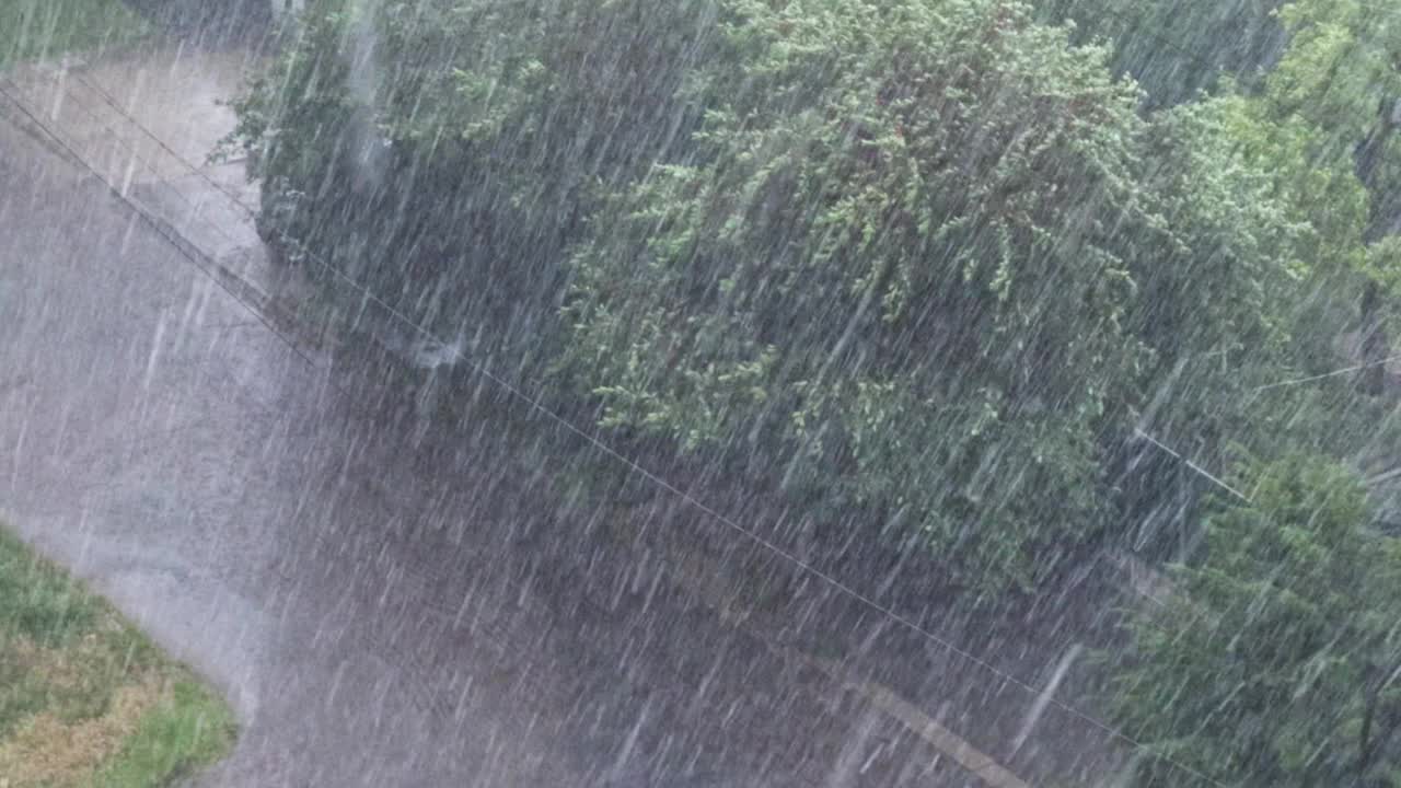 下着很大的雨，汽车沿着道路慢慢行驶，从上面看。视频下载