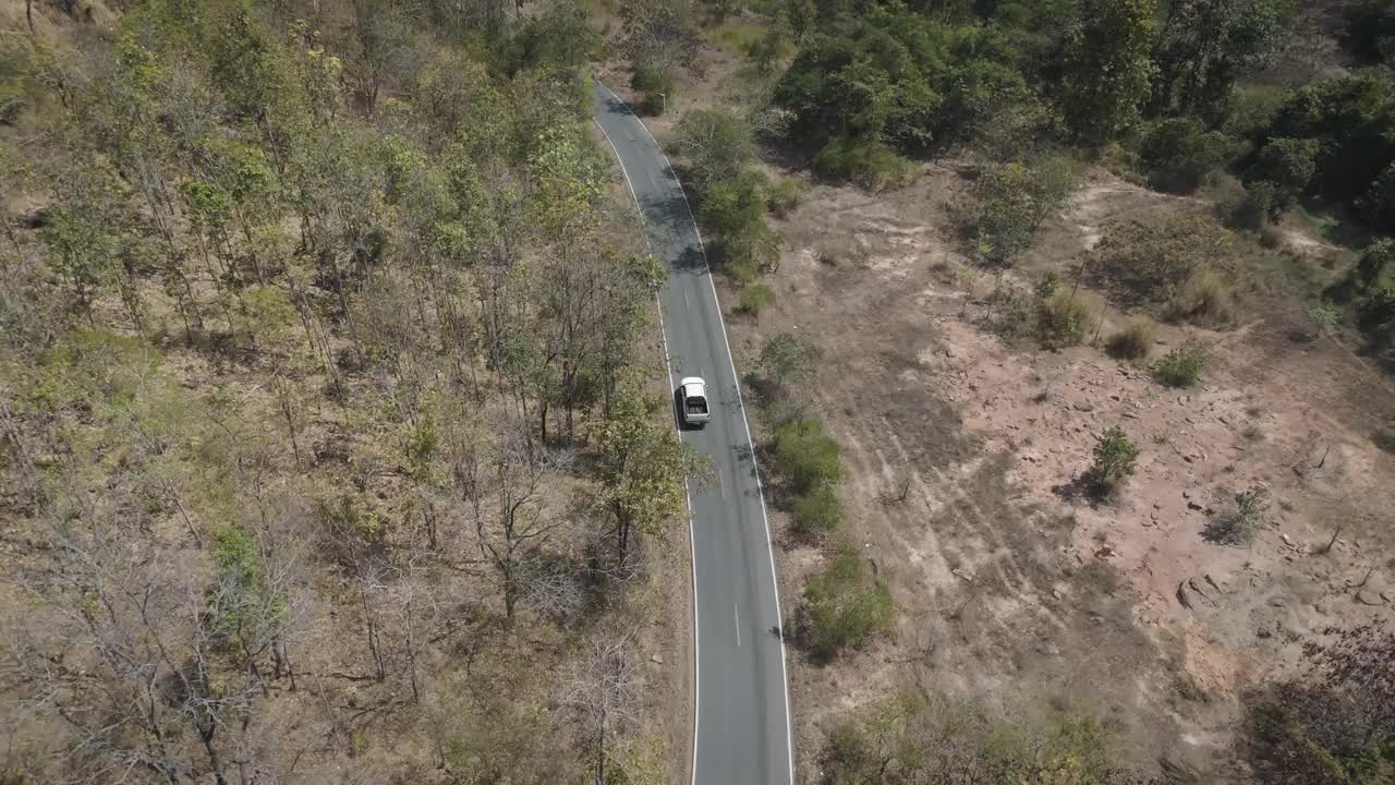 无人机拍摄鸟瞰风景，驾驶皮卡车在旱季偏僻的乡村道路上行驶视频素材