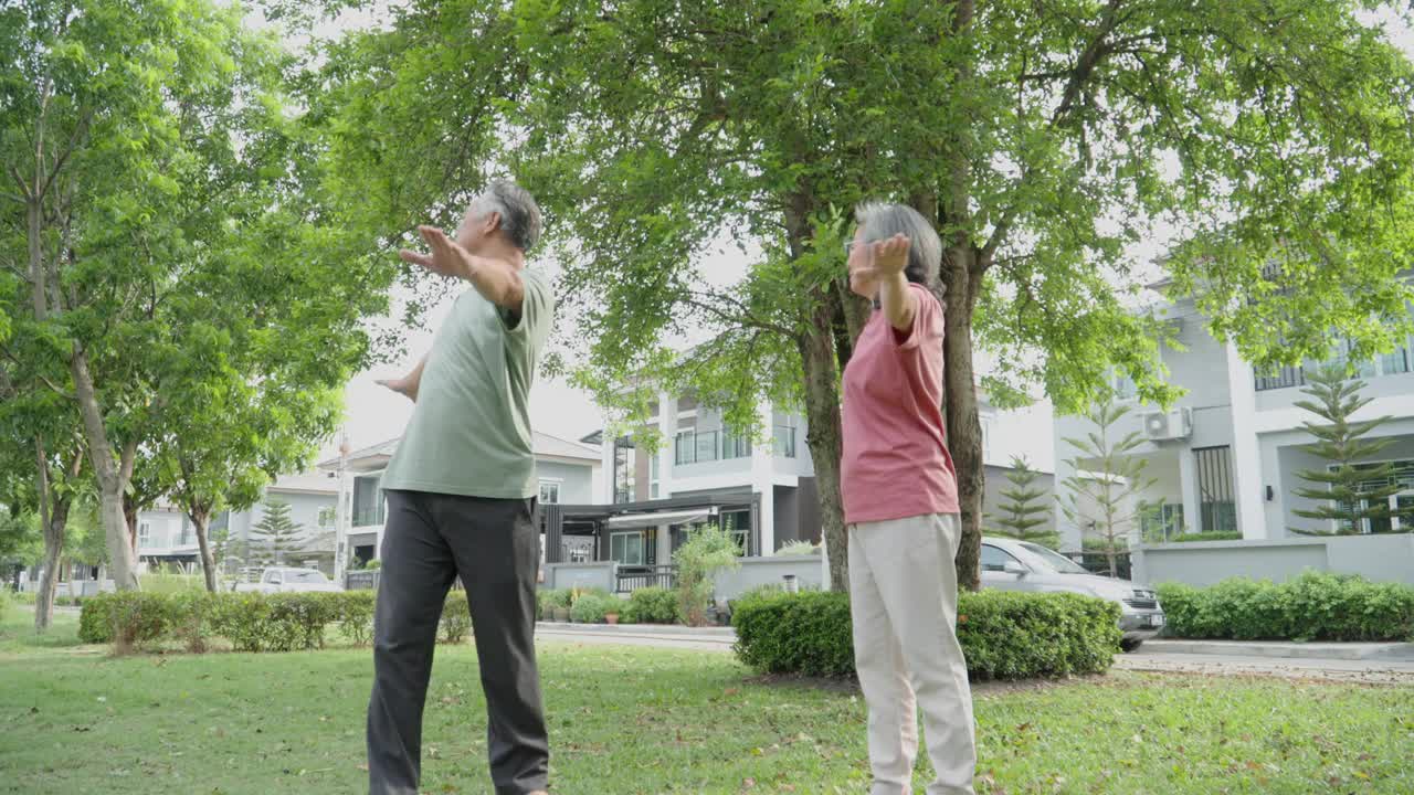 活跃的亚洲老年夫妇在公园或花园户外运动。视频素材