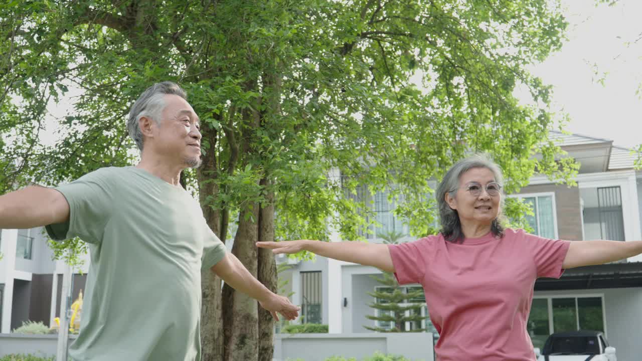 活跃的亚洲老年夫妇在公园或花园户外运动。视频下载