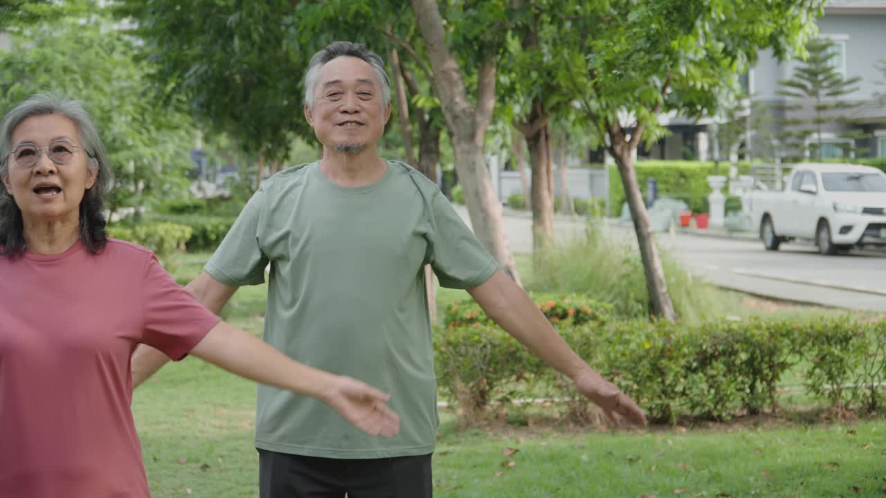 活跃的亚洲老年夫妇在公园或花园户外运动。视频下载