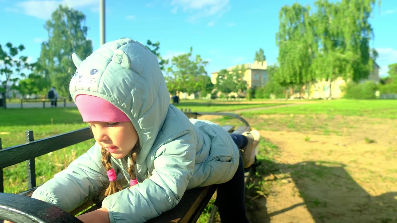 一个漂亮的孩子在公园外面玩耍和微笑。快乐的小女孩在春天的一天在外面玩耍。可爱的白人小孩在花园里散步，笑着。视频素材