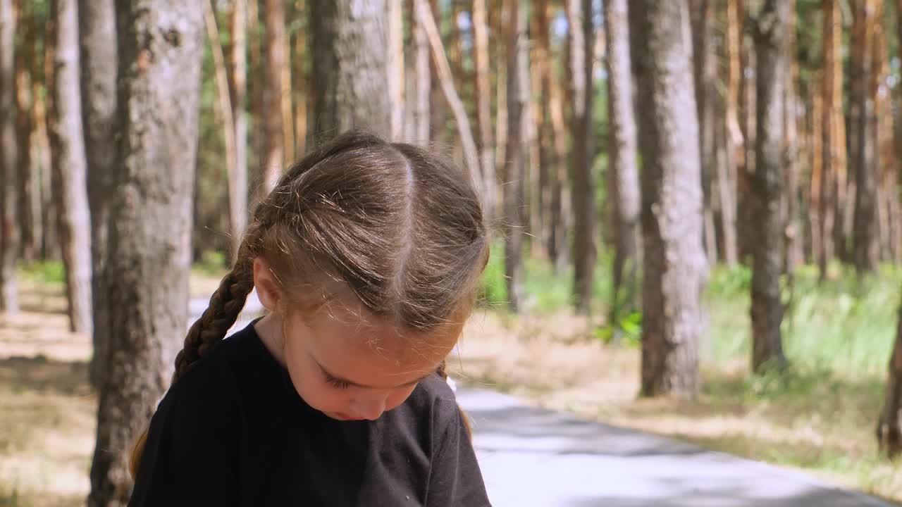 肖像的微笑小女孩在女巫服装和帽子。孩子微笑着，手里拿着橙色的南瓜灯，在街上开派对。狂欢节服装。视频素材