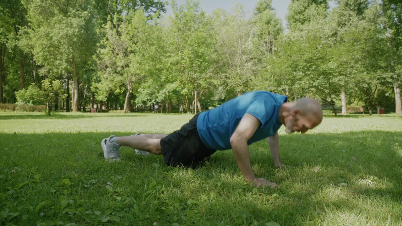 积极运动的中年男子在大自然中做高级俯卧撑运动视频素材