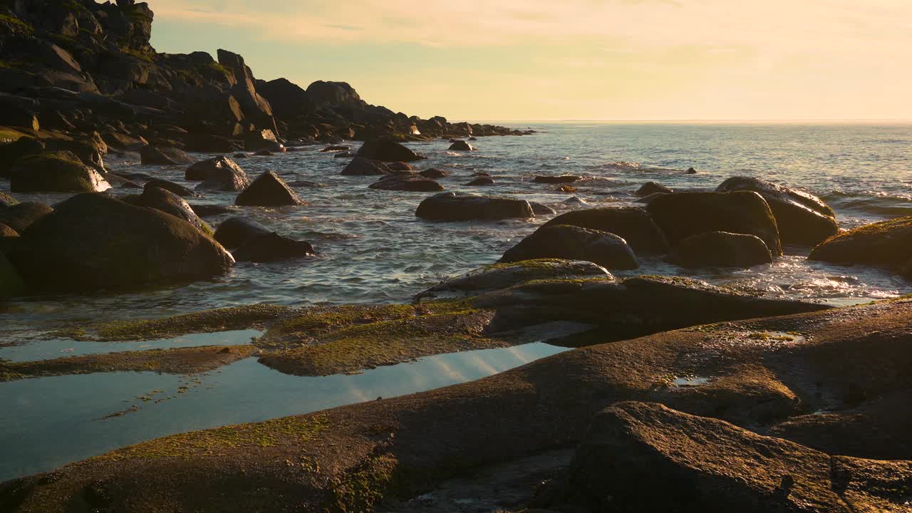 日落在挪威罗弗敦岛乌塔克莱夫海滩的岩石海岸线上视频素材