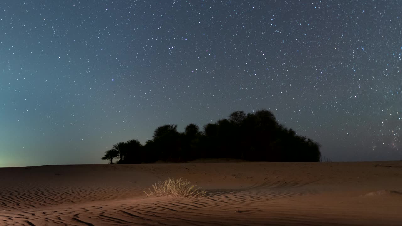 在绿洲沙漠野外露营时，夜间星空的时间流逝。视频下载