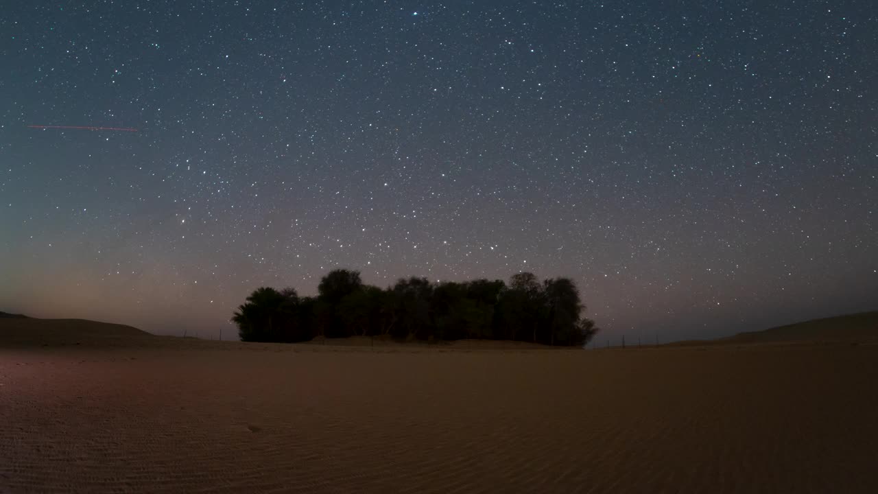 在绿洲沙漠野外露营时，夜间星空的时间流逝。视频下载