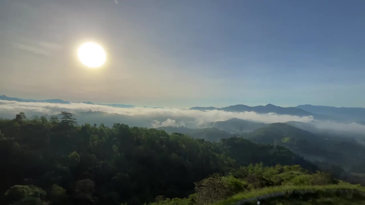 日出时山顶的全景，较低的山坡笼罩在雾的海洋中。视频下载