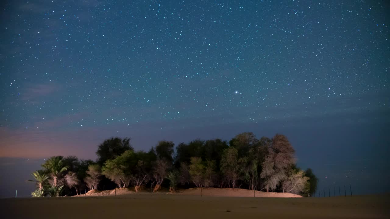 在绿洲沙漠野外露营时，夜间星空的时间流逝。视频下载