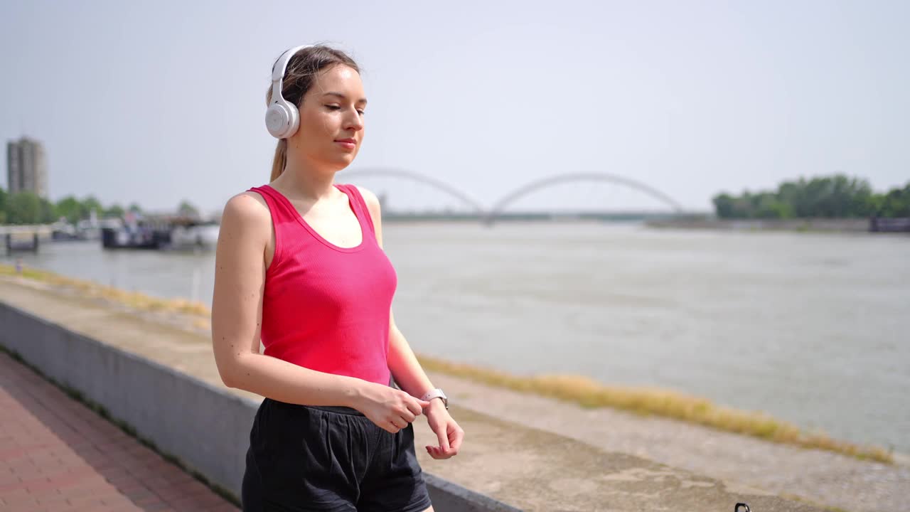 年轻的女运动员在跑步后看着智能手表视频素材