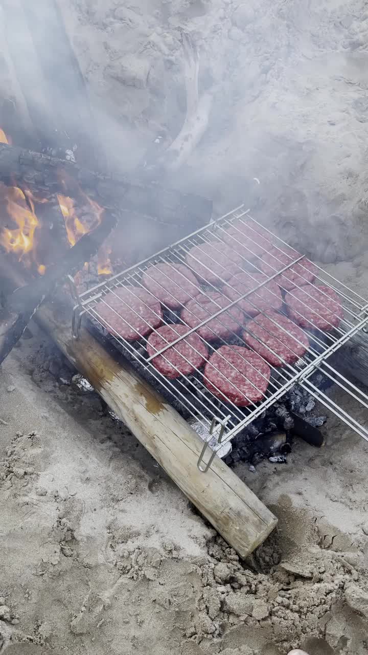 在沙滩上的篝火上烤肉饼视频素材