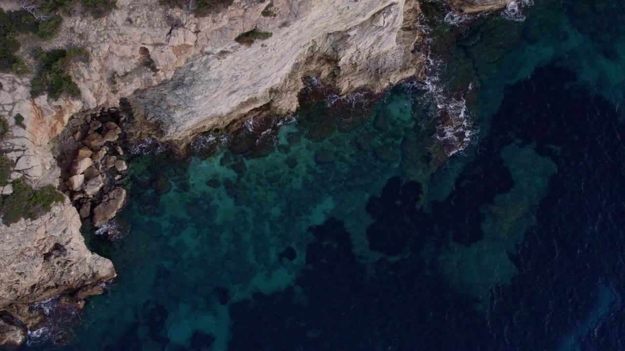 鸟瞰图的岩石悬崖和清澈的蓝色海水在日落，西班牙。视频素材