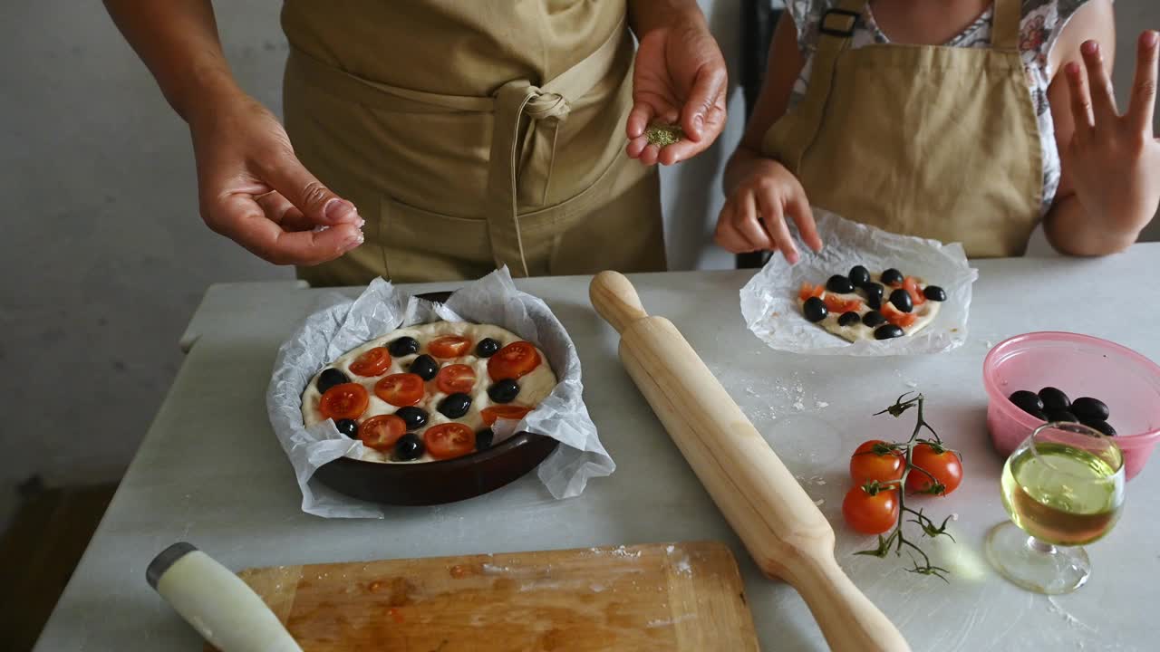 父母和孩子一起在厨房用新鲜的食材自制披萨视频素材