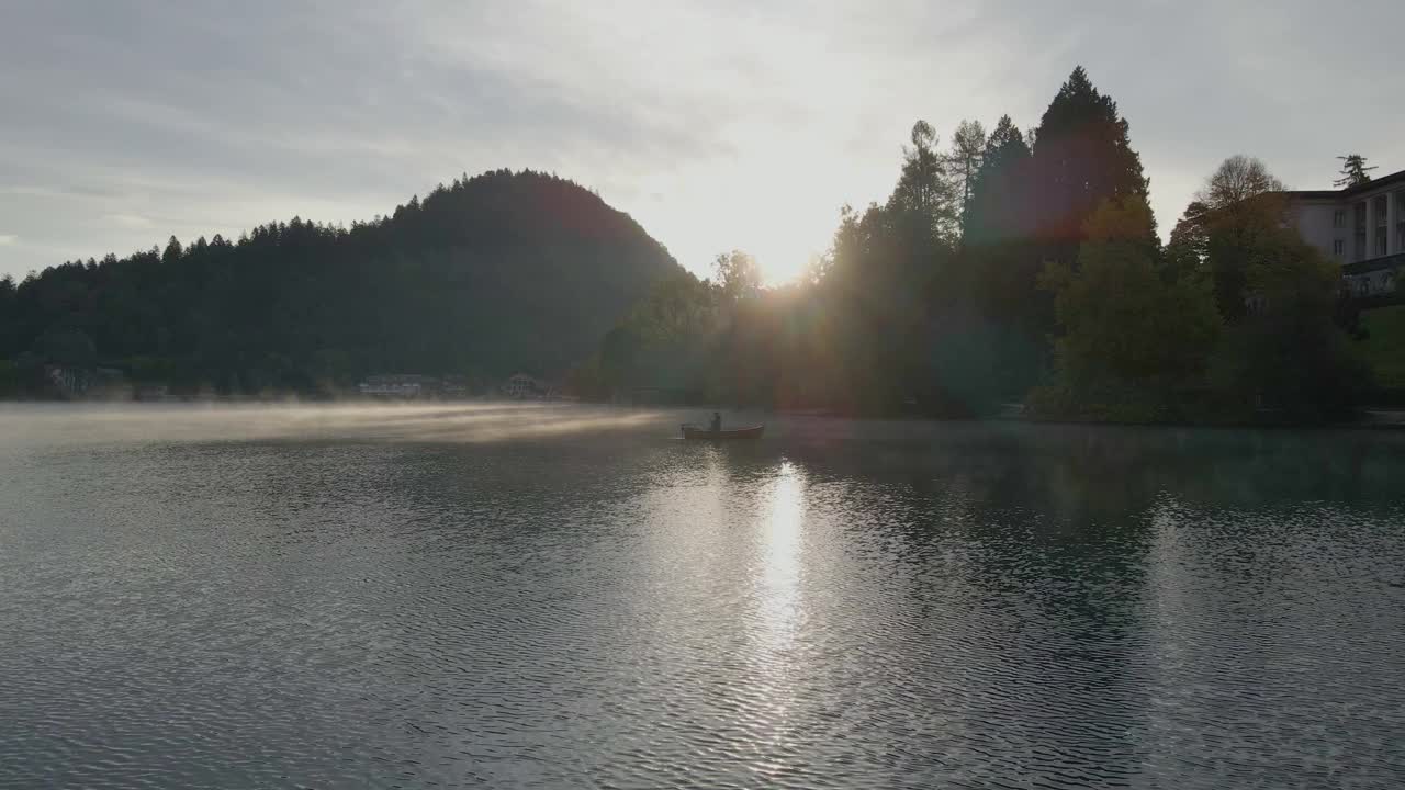 从空中俯瞰朦胧的布莱德湖和朱利安阿尔卑斯山脉在日出，布莱德，斯洛文尼亚。视频素材