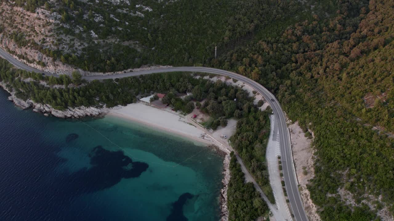 鸟瞰日落时分亚得里亚海边的海滩、道路和山脉，克罗地亚。视频素材