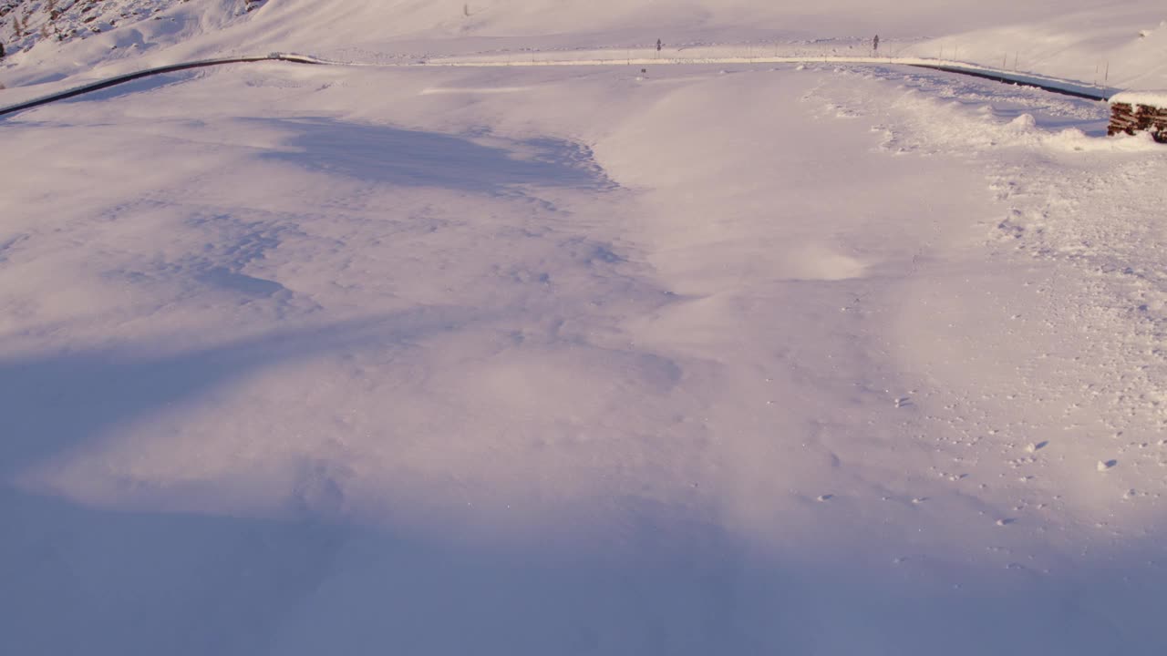 鸟瞰雪山，道路，小屋在日落意大利。视频素材