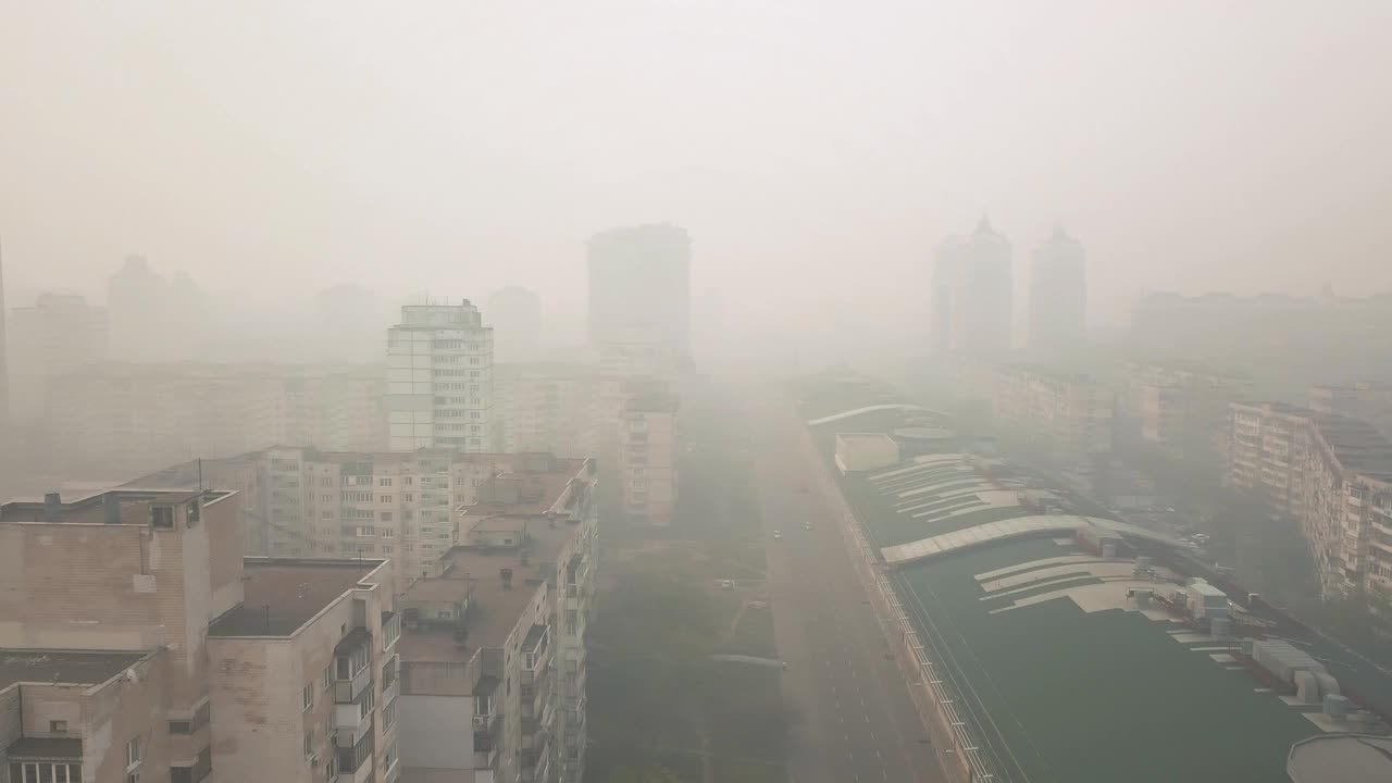 白天，从无人机上看到的城市被夏季森林大火的烟雾笼罩视频下载