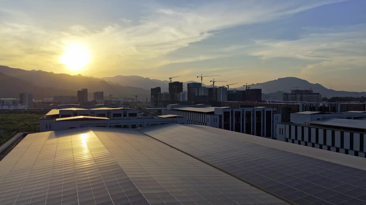 日落时分，新工业区建筑屋顶上的高角度太阳能电池板视频素材