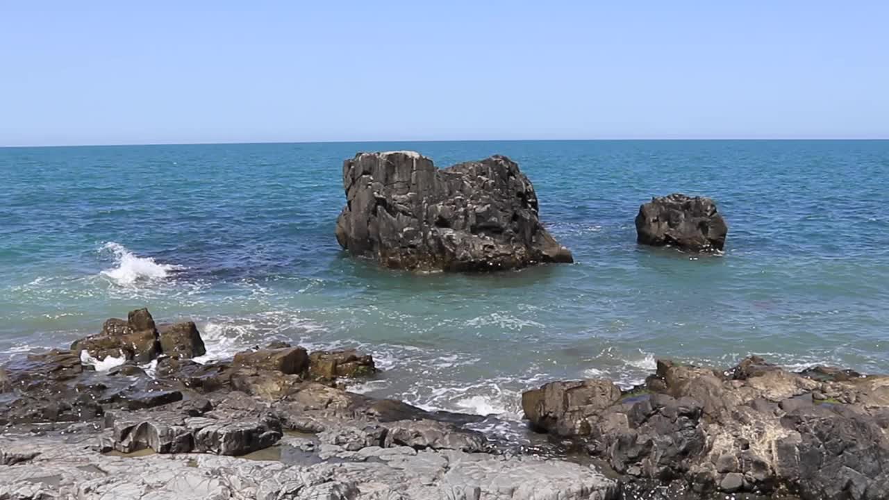 格鲁吉亚巴统附近的岩石和崎岖的海岸线，白天的海浪拍打着岩石，体现了原始的美丽和充满活力的海岸环境。视频素材