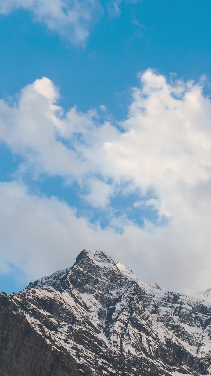 在印度喜马偕尔邦拉胡尔山谷的冈德拉，夕阳下，白雪覆盖的喜马拉雅山峰上方的橙色云的垂直延时拍摄。喜马拉雅山背景下的日落。视频素材