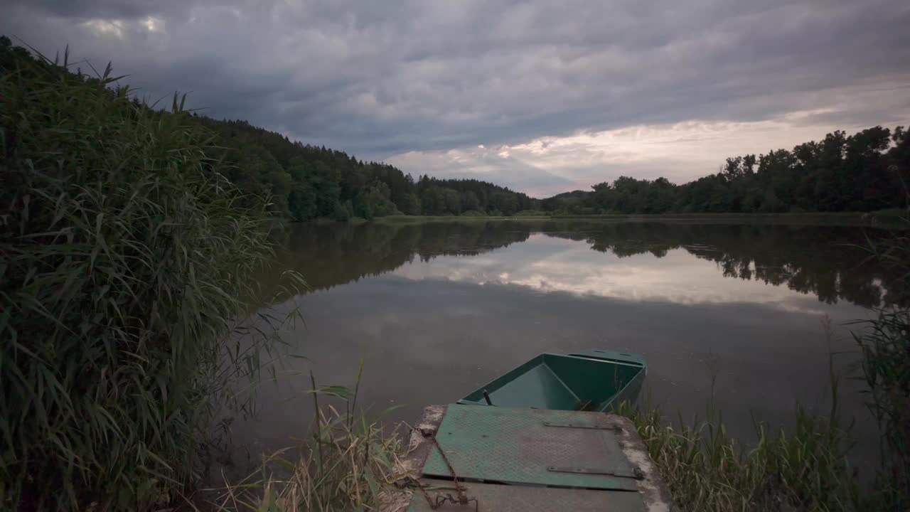 傍晚，夕阳在湖面上洒下缕缕光芒，岸边的小船营造出一种浪漫的气氛。视频素材