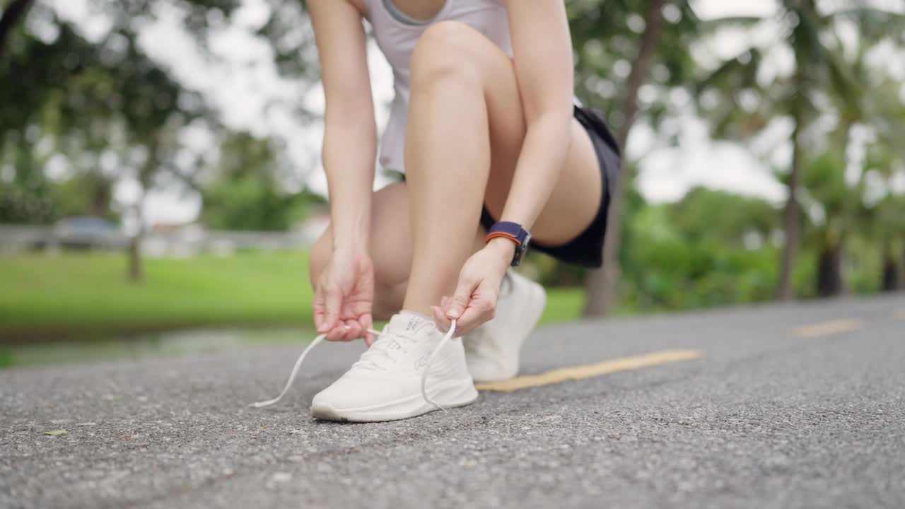 一个女人在路上系鞋带视频素材