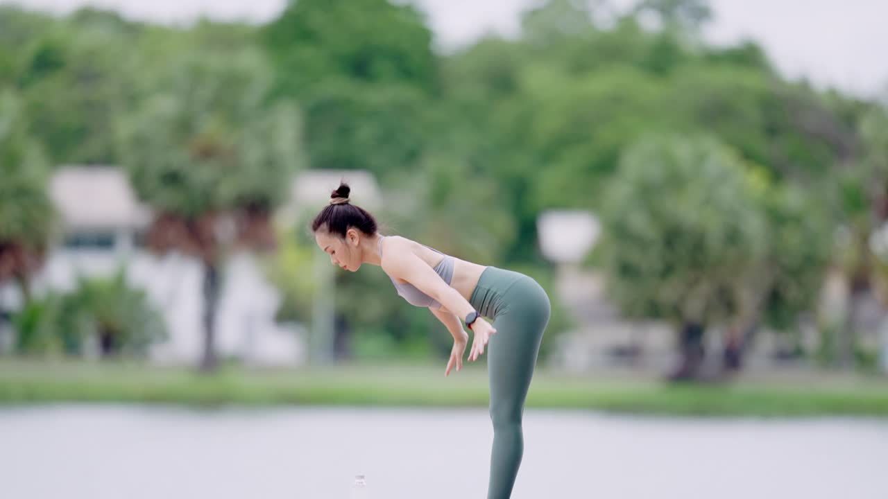 一个女人在湖边做瑜伽视频素材