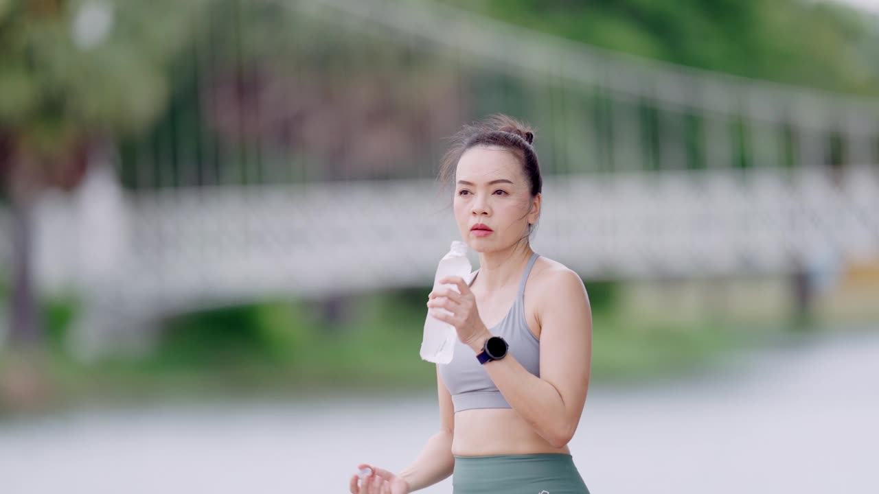 一个女人正在跑步和喝水视频素材