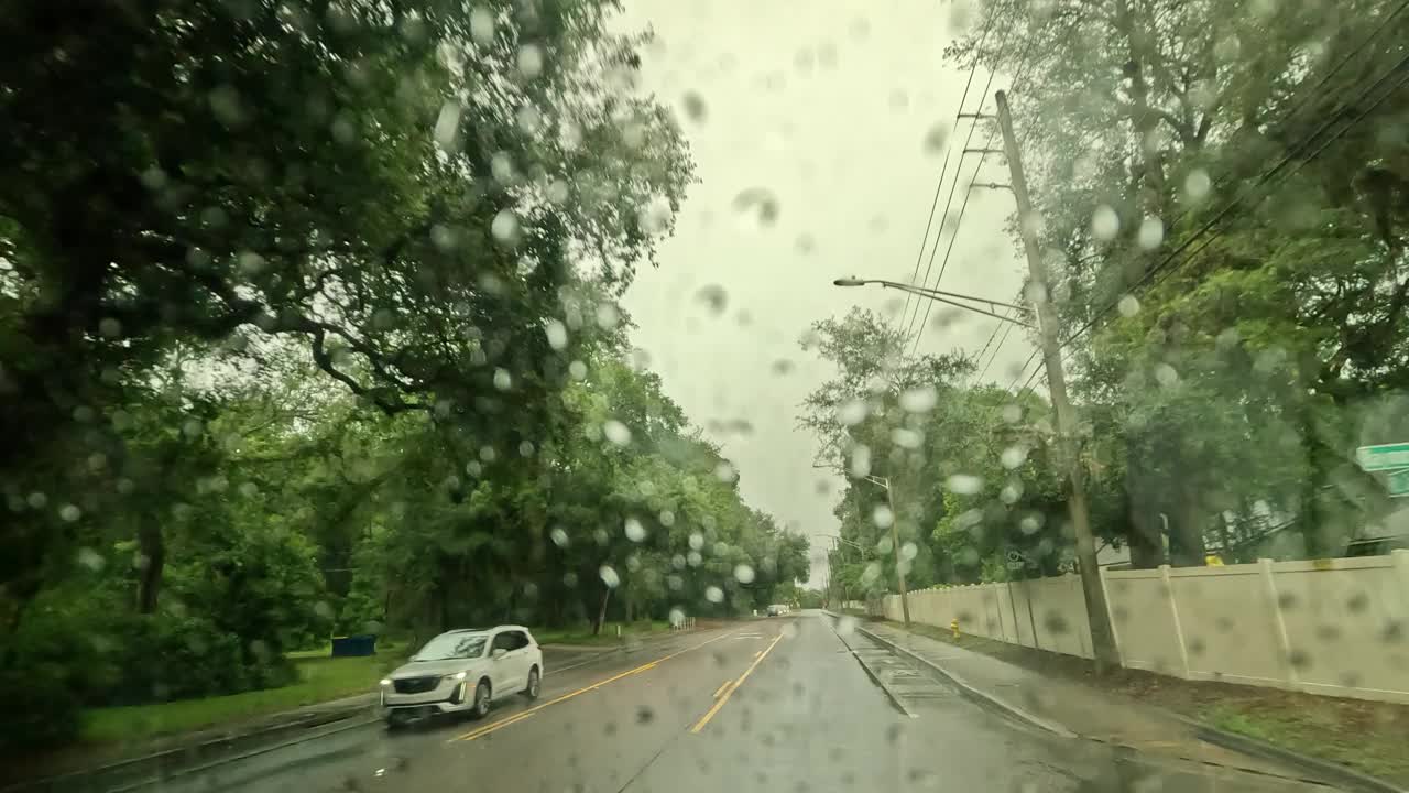 在多云的日子里，城市街道上大雨连连，路面、建筑物、交通都被打湿了视频下载