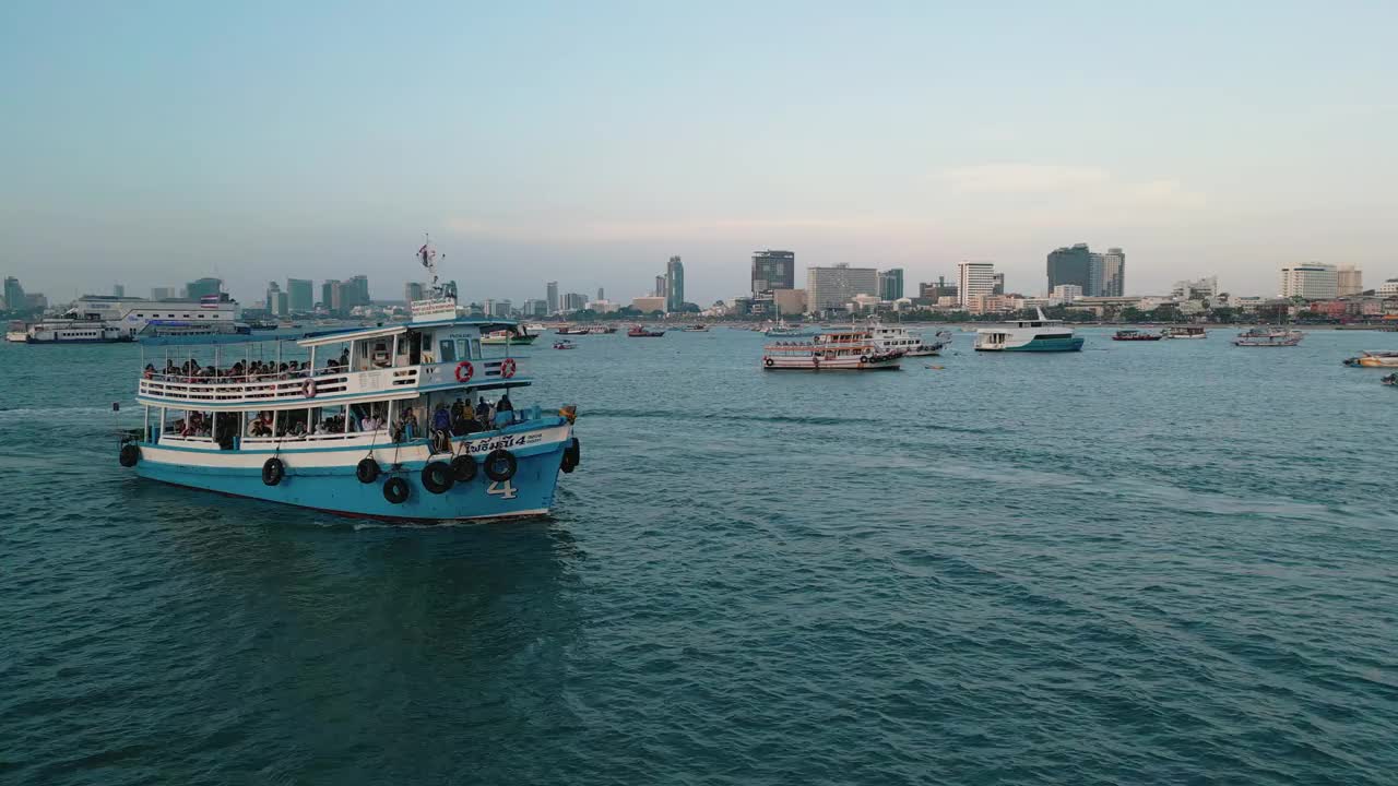 夕阳下的芭堤雅城市标志和芭堤雅快艇码头的4K无人机视图。视频素材