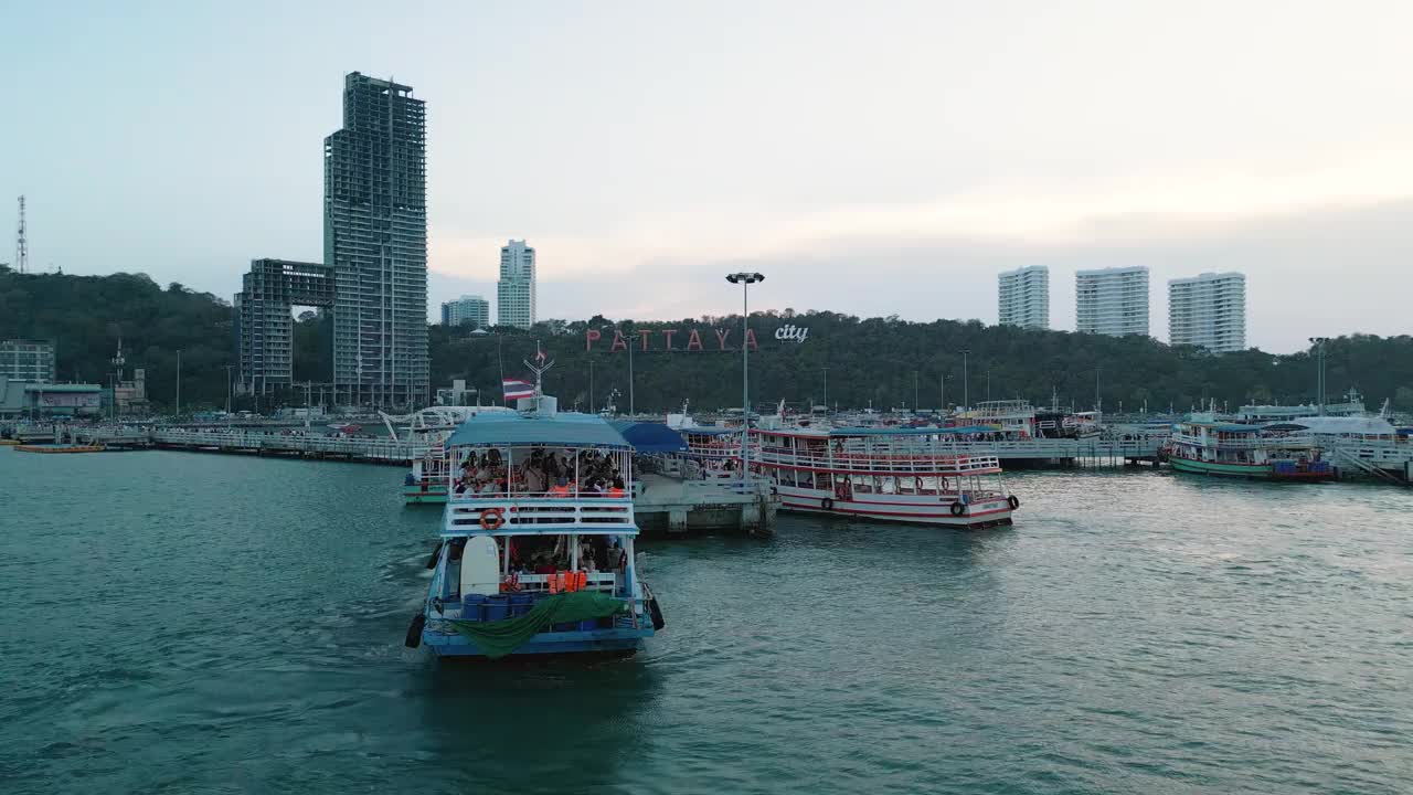 夕阳下的芭堤雅城市标志和芭堤雅快艇码头的4K无人机视图。视频素材