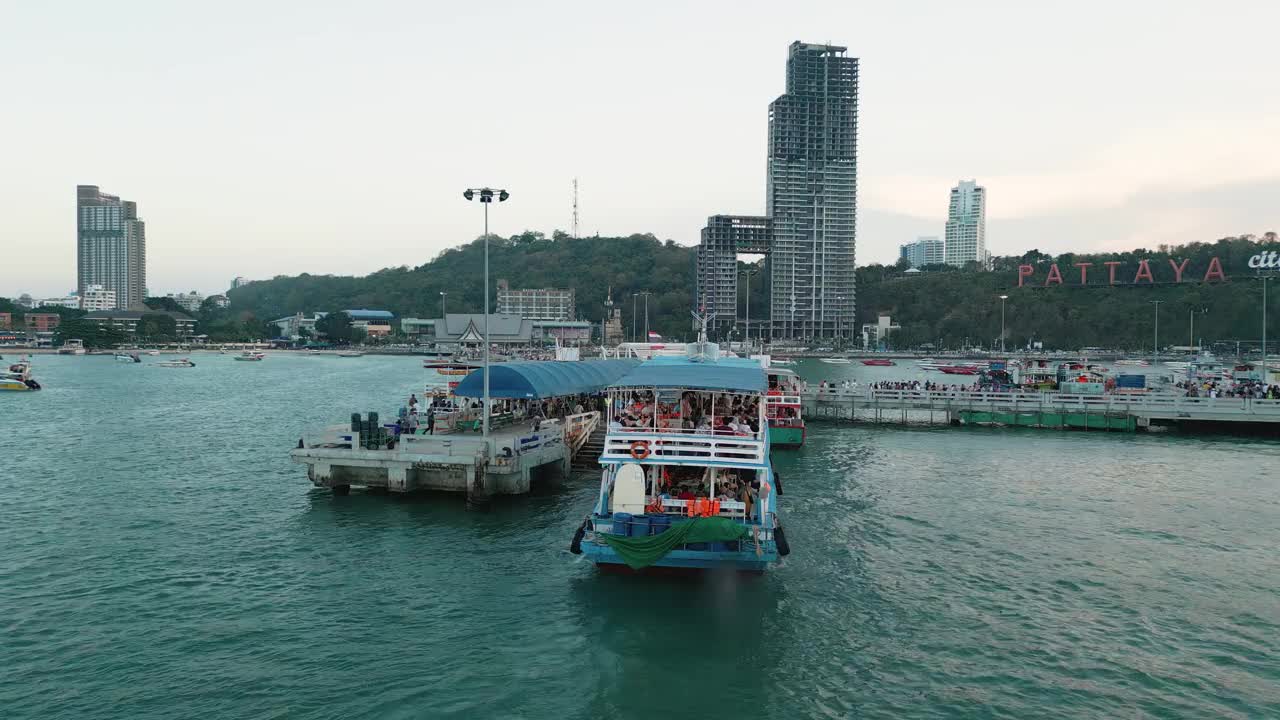 夕阳下的芭堤雅城市标志和芭堤雅快艇码头的4K无人机视图。视频下载