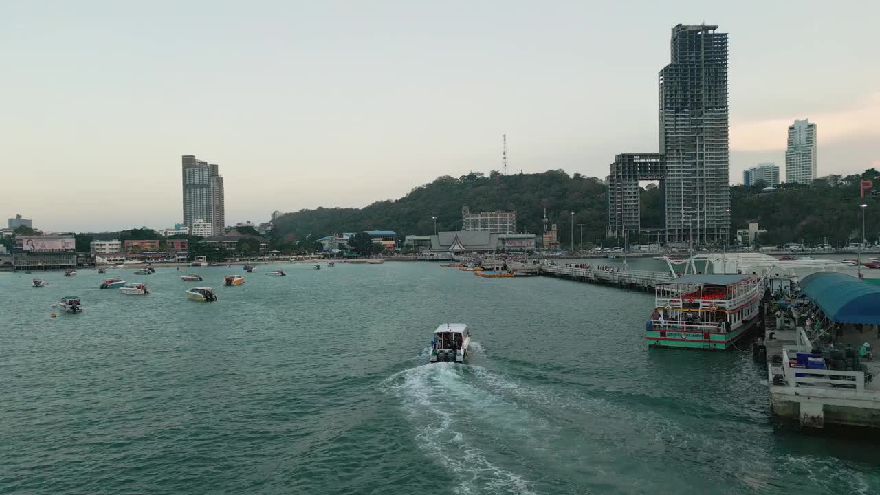 夕阳下的芭堤雅城市标志和芭堤雅快艇码头的4K无人机视图。视频素材