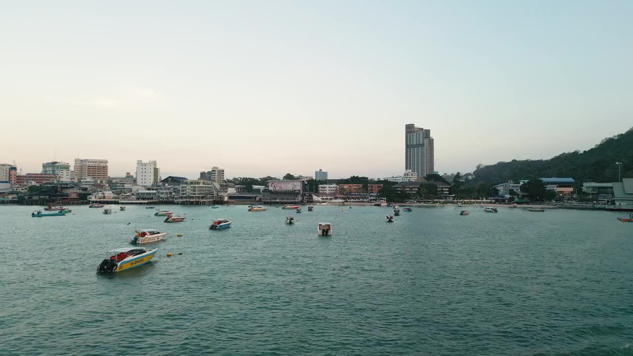 夕阳下的芭堤雅城市标志和芭堤雅快艇码头的4K无人机视图。视频下载