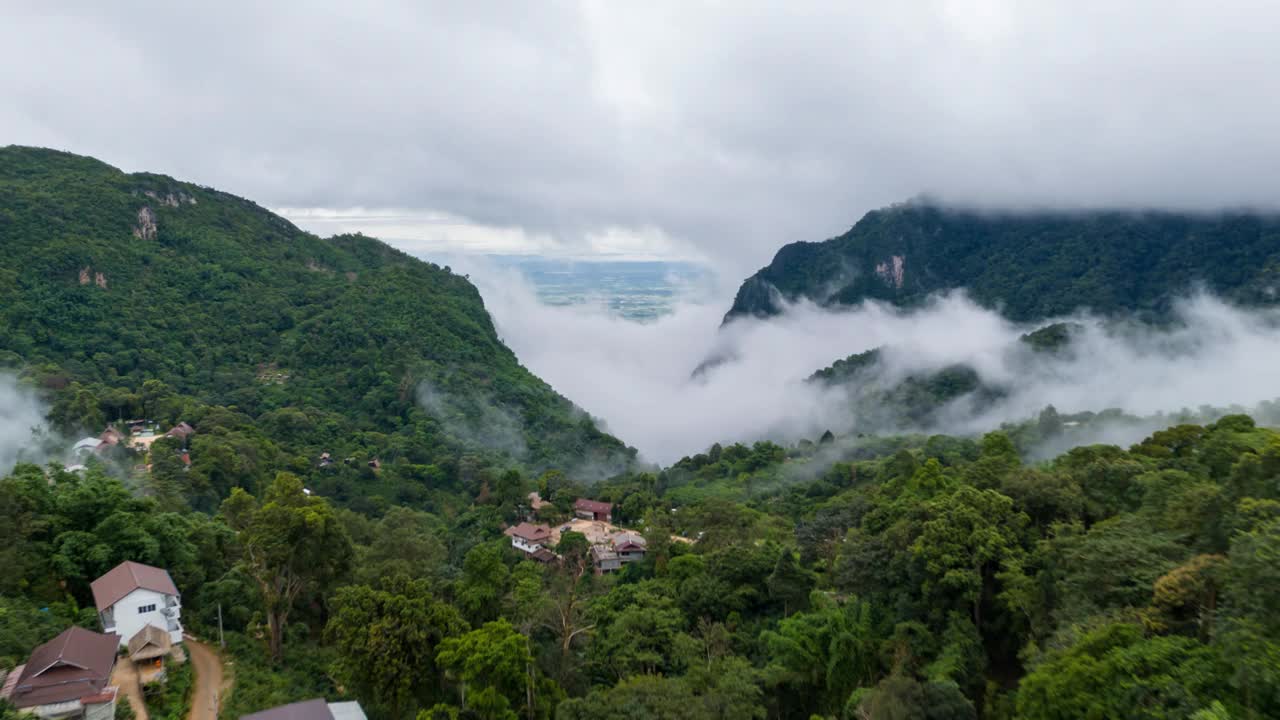 这是一幅令人惊叹的鸟瞰图，郁郁葱葱的绿色山脉和雾蒙蒙的山谷，在阴天展示了大自然的美丽。视频下载