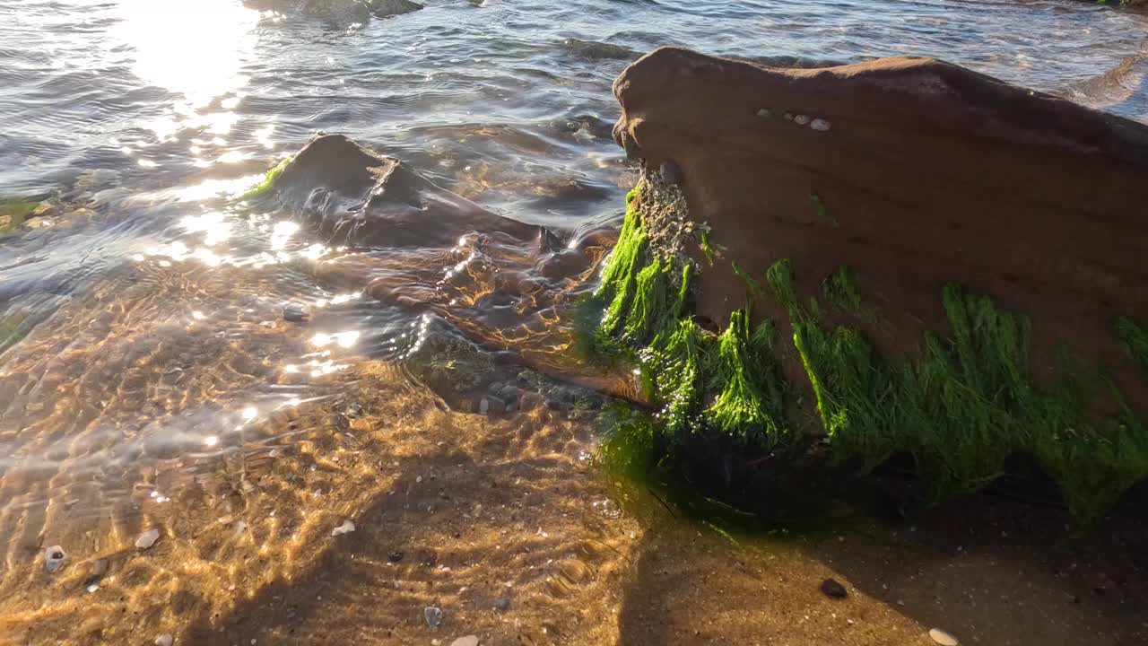 海浪拍打着长满青苔的岩石视频素材